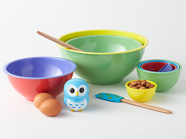 Sleek, nested melamine items: two-toned mixing bowls and multi-colored measuring cup set.  Wooden spatulas with non-stick friendly silicone heads with custom artwork, and peppy owl timer.